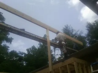 Carpenter setting a ridge beam over a new addition frame — Ice Dam Removal by Roofing Brothers in Alburtis