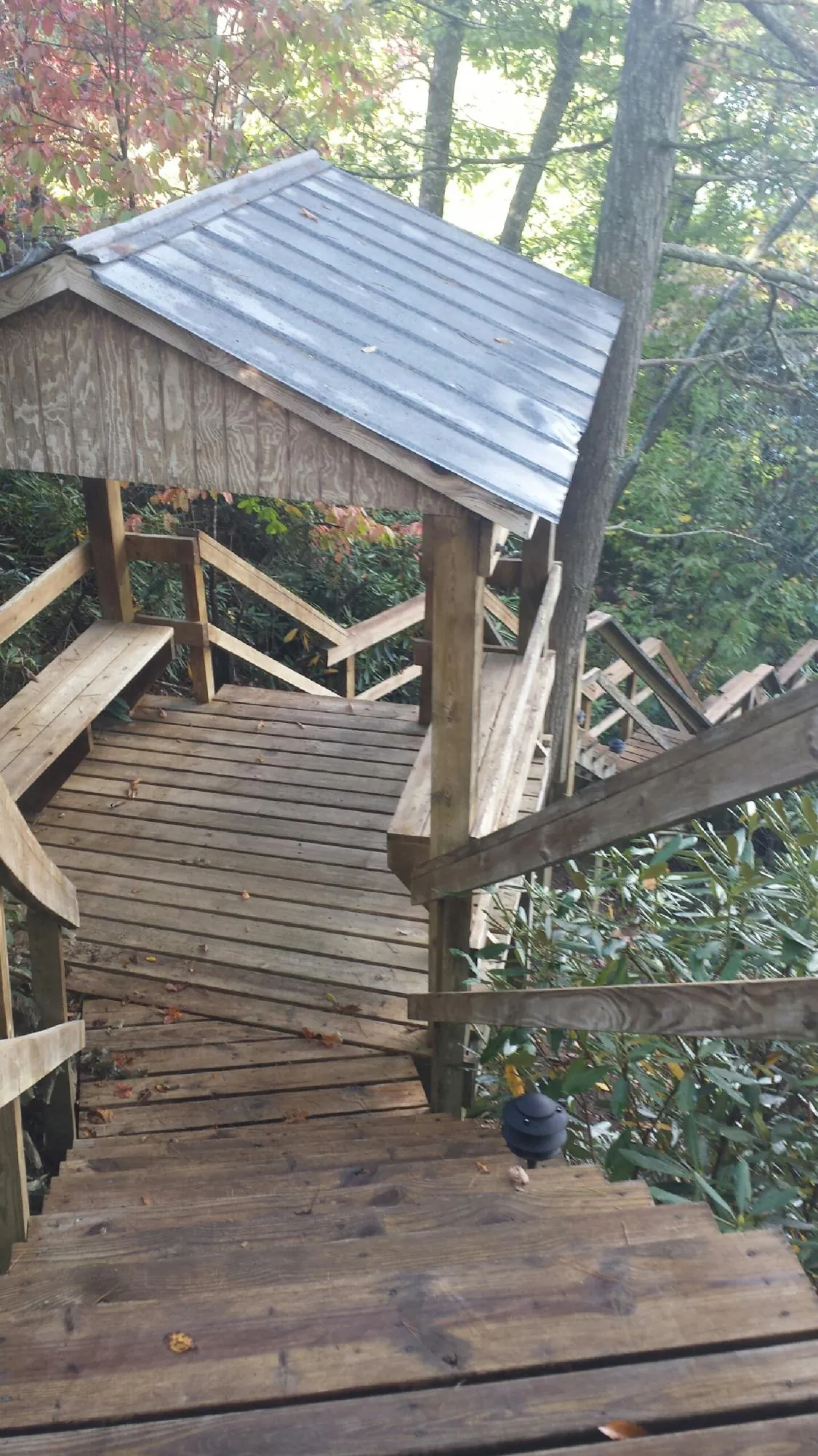 Metal roofed shelter over wooden steps on a wooded walkway — Skylight Repair & Installation work by our crew in Alburtis