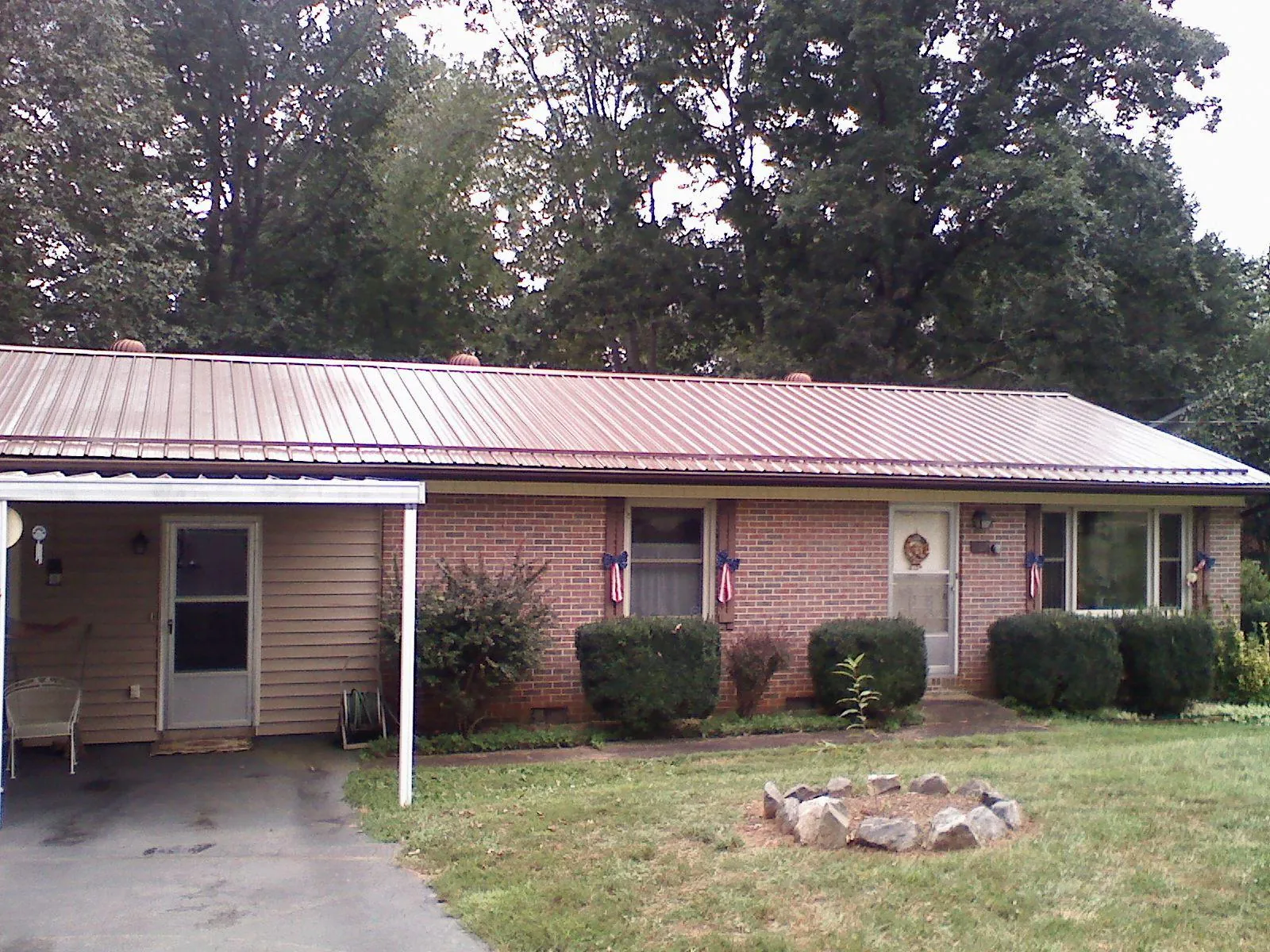 Bronze metal roof and carport on a brick ranch home — Roof Repair work by our crew in Alburtis